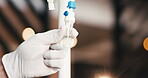 Doctor, hands and iv drip in clinic with medicine dose, patient wellness and hydration benefits. Bokeh, healthcare person and press intravenous tube with liquid for supplements, nutrients or vitamin.