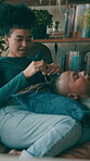 Couple, break and playing with hair, living room and bonding with woman in home, comfortable or rest. Happy, black people and talking in lounge on weekend, love and romance with partner in house