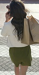 Outdoor, phone call and woman with shopping bags, walk and communication with contact or discussion. Back, conversation and person with mobile on urban street, laughing and excited for sale and above