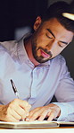 Finance, night and man in office with writing, funding ideas or data analysis for budget pitch. Review, graphs and analyst in agency with notebook, financial report or proposal planning in overtime