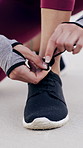 Person, hands and tie with shoes on beach for fitness, workout preparation or outdoor exercise. Closeup, active or runner getting ready with sneaker or tying laces on sandy shore for training or run