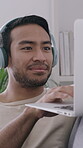 Creative, laptop and man with headphones, home and author with freelance project, smile and research. Happy, writer and person with tech for article on website, remote work and listening to music