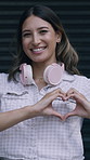 Happy woman, face and headphones with heart emoji for love, romance or connection on garage door. Portrait, female person or smile with like emoji, shape or romantic gesture for care or passion