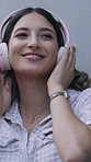 Happy woman, singing and listening with headphones for music or audio streaming on wall background. Female person, dancing or smile with sound, songs or network for subscription, playlist or podcast