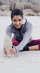 Happy woman, face and stretching with leg on beach for workout preparation or flexibility. Active, female person or getting ready with body warm up on sandy shore or ocean coast for fitness exercise