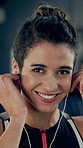 Earphones, fitness and face of woman in gym with satisfaction for training or workout. Exercise, music and smile or portrait with happy athlete streaming radio in health club for cardio or challenge