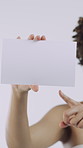 Hands, poster and pointing in studio with promotion, mock up space and news on white background. Girl, blank sign and advertising with board, sale and announcement for discount or deal for marketing