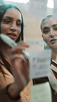 Creative, business women and planning with sticky note for brainstorming or project schedule. Female people, employees or colleagues with glass board, ideas or collaboration for work agenda or tasks
