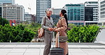 Happy woman, travel or suitcase with handshake in city for business meet up or greeting together. Female people, employee or colleagues shaking hands with luggage for partnership or b2b in urban town