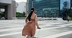 Luggage, business woman and running in city for travel delay, check watch and late for flight. Work trip, back of person and hurry with suitcase outdoor for international journey and time management