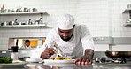 Plating, man and chef in kitchen for fine dining at restaurant for meal preparation, presentation or garnish. Food, hospitality career and culinary worker for cuisine flavor with catering at diner.