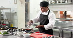 Cooking, meal and man in restaurant with preparation, culinary process or catering in food industry. Hospitality, professional or chef with ingredients, cuisine service or dish production in kitchen