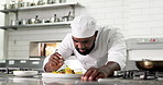 Black man, garnish and cooking food in restaurant kitchen for meal preparation with plating technique. Chef, culinary and presentation with cuisine, salad flavor and dish aesthetic for luxury dinner
