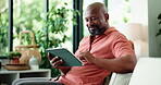 Reading, typing or black man with tablet in home, browsing internet or search subscription site for film. Smile, check preview or person with tech for movie choice, video selection or streaming app