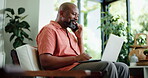 Phone call, laptop and black man in living room with freelance, financial advice and chat in home. Remote work, account manager and mature person with tech for communication, smile and discussion