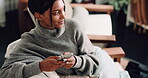 Phone, scrolling and thinking with happy woman on sofa in living room of home for social media browsing. App, smile and typing message with Indian person in apartment for ideas, planning or vision