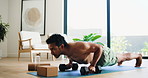Man, fitness and push ups with dumbbells in home for exercise, muscle gain or training. Active, muscular or male person with equipment or weights for strong core, arm or chest workout on mat in house