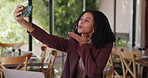 Happy woman, blowing kiss and cafe with selfie for memory, picture or capture moment in restaurant. Female person, customer or user with smile or post for photography or social media in coffee shop