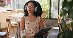Remote work, headphones and woman with tablet in cafe for freelance job, feedback and digital report. Thinking, music and tech in coffee shop for travel blog, communication and review of website