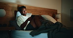 Tablet, night and man in bedroom with insomnia, streaming movie and watch show online for relax. Home, bed and sleepless person with technology for film, video and smile with internet addiction