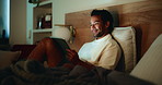Night, man and watching video in bed with tablet for entertainment, comedy series and film in home. Late, comfortable person and laugh in apartment with tech for streaming funny movie, show or relax.