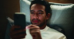Scroll, night and man with phone in bedroom for insomnia, watch video and social media for relax. Home, bed and sleepless person with mobile in evening for movie search, smile and internet addiction