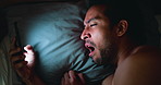 Night, man and yawn in bed with phone for social media, entertainment and online communication. Late, exhausted person and scroll in apartment with tech for mobile app, text message and sleepless.