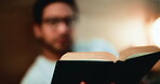Night, hands and man reading book in bedroom for entertainment, calming activity and literature. Late, person and comfortable with novel in house for relaxing hobby, fiction story or bedtime routine.