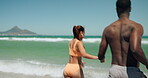 Travel, waves or couple at beach with holding hands, bonding or vacation freedom on romantic trip. Tourism, ocean date or people in water with adventure, playful energy or summer connection in Cancun