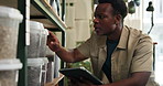 Nursery, store and black man on tablet for soil inventory for growth, sustainability and healthy plants. Gardening, florist and person on digital tech for fertilizer, compost and nutrients on shelf