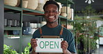 Smile, open sign and face of black man in store for sustainability, plants or greenery at small business. Board, happy and portrait of African botanist with announcement at at eco friendly nursery.