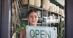 Florist, woman and happy with open sign at window for public notice, start day or welcome message. Storefront, employee and smile with signage at plant shop for sustainable startup and advertisement