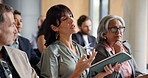 Business, tablet and question with woman in audience of development seminar for feedback or solution. App, conference and speaking with mature employee in crowd of workshop for discussion or query