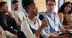 Business, microphone and question with woman in audience of development seminar for feedback or solution. Asking, conference and speaking with employee in crowd of workshop for discussion or query