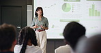 Business woman, graphs and presentation for strategy in seminar room with audience. Training, forum speech and statistics with corporate growth for public speaking, education and convention for crowd