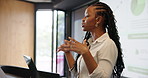 Data, laptop and speech with business black woman at podium for development workshop. Computer, projection screen and stage presentation with speaker in convention center for seminar or symposium