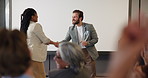 Business people, applause and handshake for award, celebration ceremony and smile at seminar. Clap, shaking hands or congratulations for achievement, success or giving trophy with conference audience