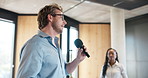 Advice, inspiration and microphone with motivational speaker man in office for life coaching. Business, crowd and speech with person in workplace for employee development, pep talk or support