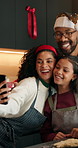 Happy family, kitchen and christmas with selfie for picture, bonding or december holiday together. Mom, dad and child with smile or hug for photography, capture moment or festive celebration in home