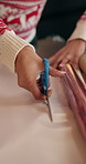 Christmas, hands and woman with scissors, wrapping paper and gift with festive season. House, cutting and person with Xmas decoration, preparation and packaging with present, celebration or tradition
