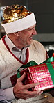 Grandfather, smile and giving with gift for Christmas, holiday celebration and bonding together. Surprise, senior man and present with xmas party, gratitude and reunion or festive event in home