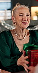 Grandmother, smile and giving with gift for Christmas, holiday celebration and bonding together. Surprise, senior woman and present with xmas party, gratitude and reunion or festive event in home