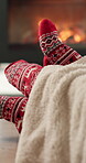 Fireplace, feet and couple with Christmas socks for holiday celebration, matching clothing and romance. Festive season, cozy winter and people with affection by flames, support and connection in home