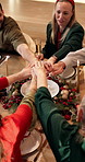 Stack of hands, christmas and family in home for dinner with bonding, unity or connection. Love, solidarity and top view of people with festive celebration together for xmas feast in dining room.