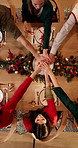 Stack of hands, christmas and people in home for dinner with bonding, unity or connection. Love, solidarity and top view of family with festive celebration together for xmas feast in dining room.