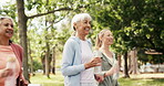 Fitness, walking and senior woman in park with friends, mobility training or cardio workout for health. Retirement, outdoor exercise or elderly people with water bottle for wellness, smile and active