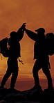People, silhouette and high five for hiking, sunset sky and friends on mountain with support on adventure. Men, goals and success on rocks, space and celebration in summer for trekking challenge