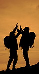 Hiking, high five and silhouette of people on mountain for adventure, journey and travel together. Friends, morning and men for backpacking, trekking and wellness for fresh air, explore and weekend