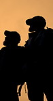 Hiking, talking and silhouette of people on mountain for adventure, journey and travel together. Friends, below and men for backpacking, trekking and wellness for fresh air, hobby and sightseeing