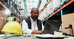 Laptop, logistics and typing with man at desk in warehouse for distribution or shipping update. Computer, management and supply chain with mature person in storage depot for agenda or schedule